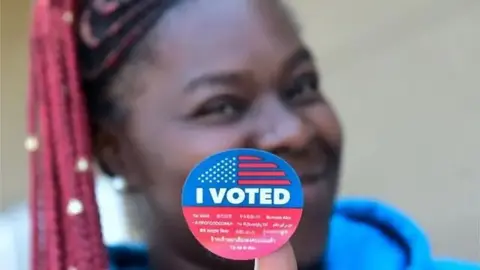 Mujer lleva un letrero que dice "Yo voté". 